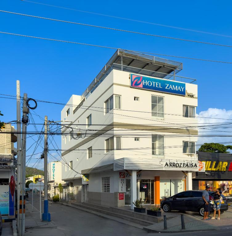 a white building with a sign on top of it at Hotel Zamay Gaira in Santa Marta