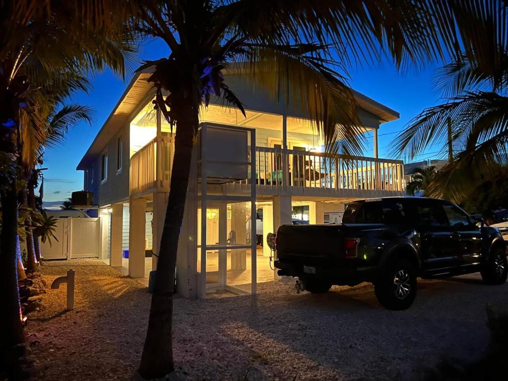 a black truck parked in front of a house at Casa Blue Pelican. in Marathon