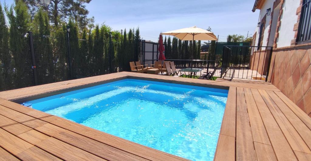 - une piscine sur une terrasse en bois avec un parasol dans l'établissement Casa el Rancho Grande, à Alora