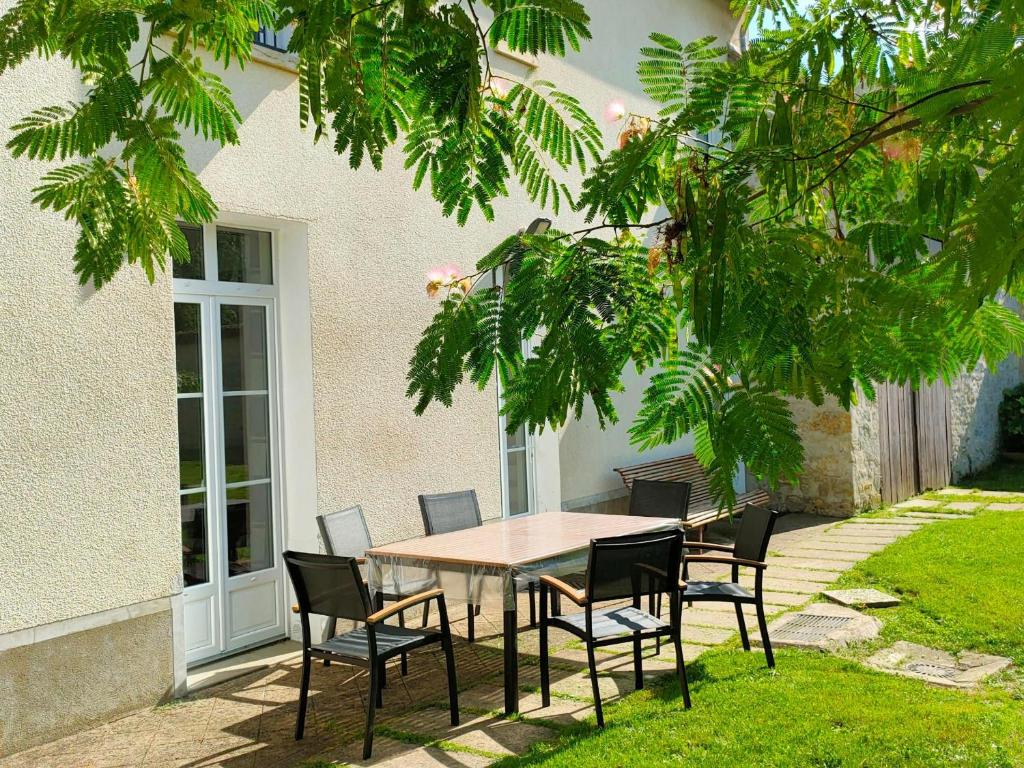 einen Tisch und Stühle vor einem Haus in der Unterkunft Gîte La Neuville-sur-Essonne, 4 pièces, 6 personnes - FR-1-590-107 in La Neuville-sur-Essonne