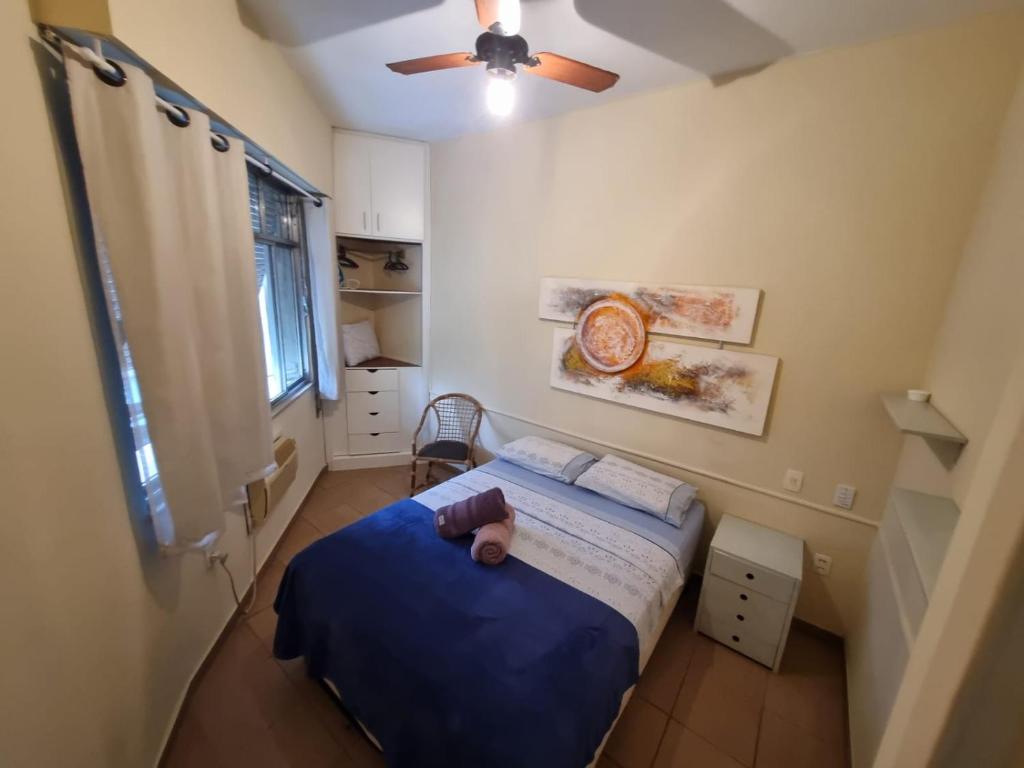a small bedroom with a bed and a ceiling fan at Copacabana Posto 6 até 3 pessoas in Rio de Janeiro