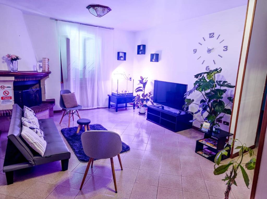 a living room filled with furniture and a clock on the wall at Charlie's Home Arezzo-Appartamento-B&B Arezzo con Parcheggio privato- Arezzo Città del Natale 2023 - Centro Arezzo Fiere e Congressi- Mercatini Natale Arezzo Casa di Babbo Natale e Villaggio Tirolese 2023 in Arezzo