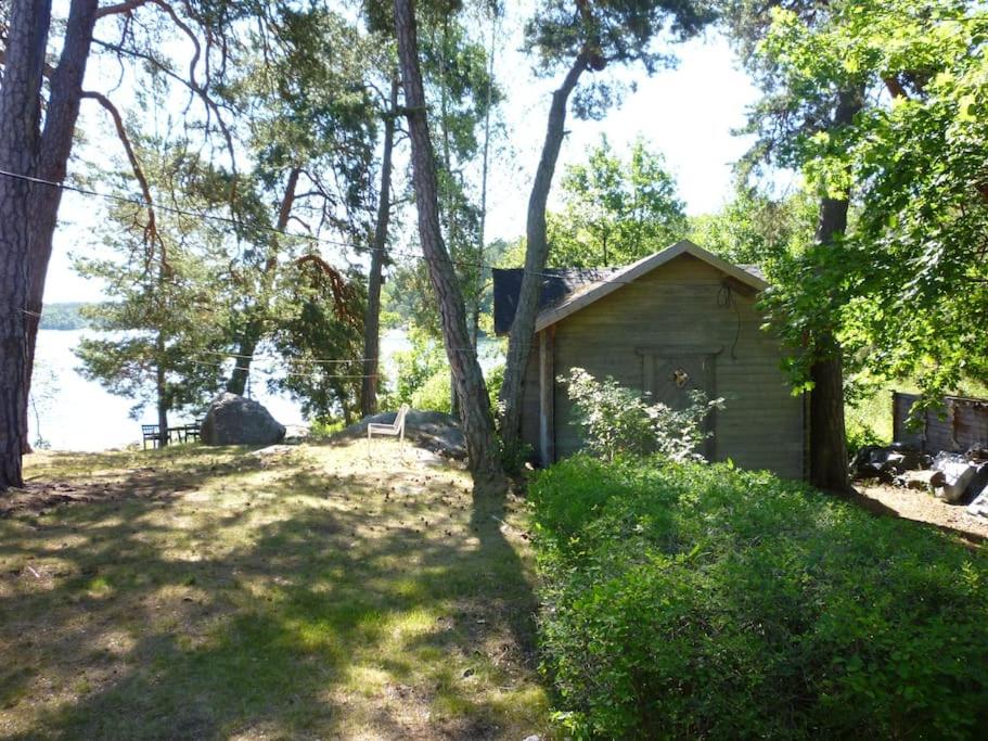 a small shed in the middle of a field with trees at Houses by the sea near the city in Lidingö