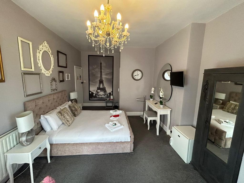 a living room with a bed and a chandelier at The Lyndhurst Guest House in Great Yarmouth