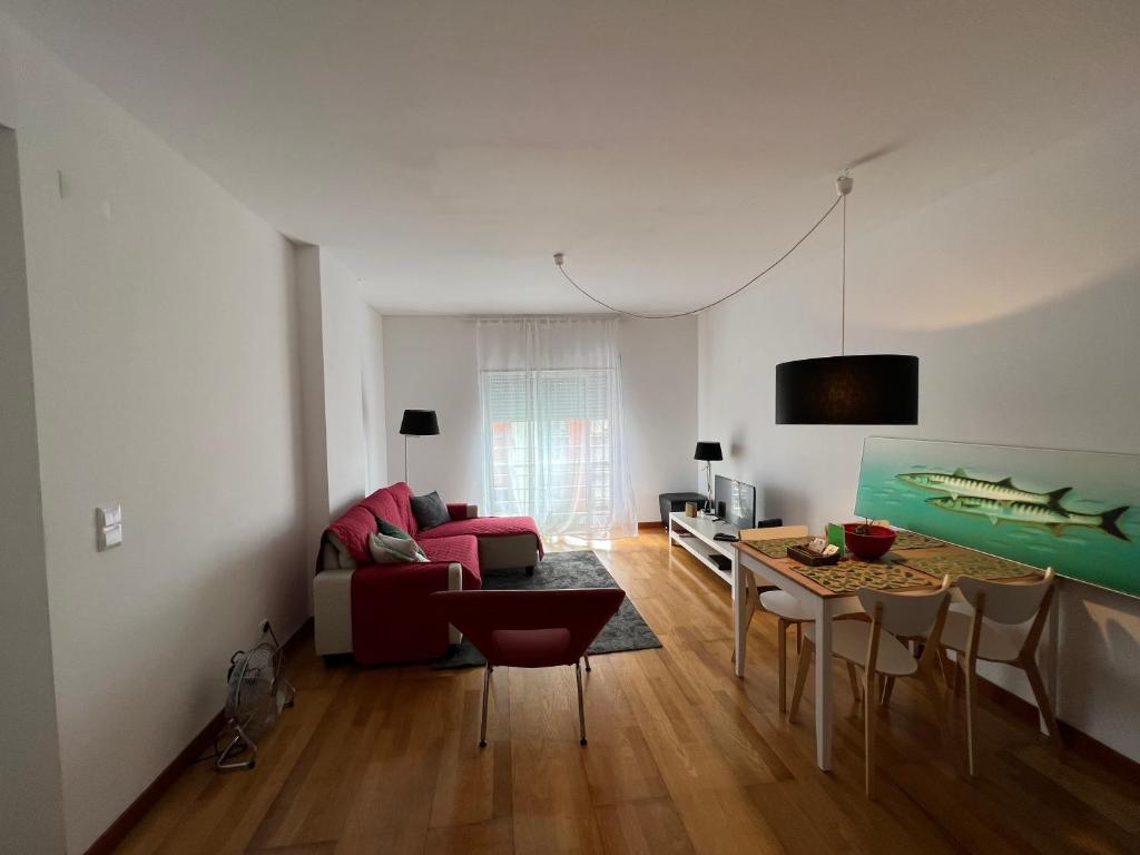 uma sala de estar com um sofá e uma mesa em Apartamento do Atlântico em Ponta Delgada