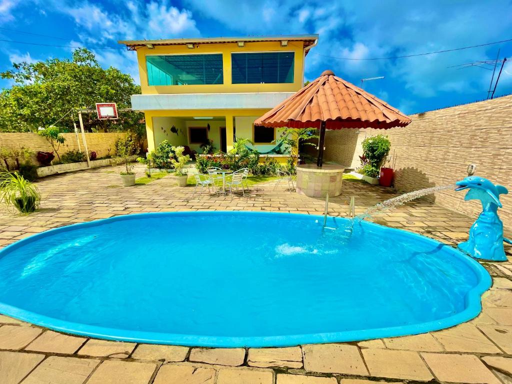 a large blue pool in front of a house at Casa Ilha de Itamaracá in Vila Velha