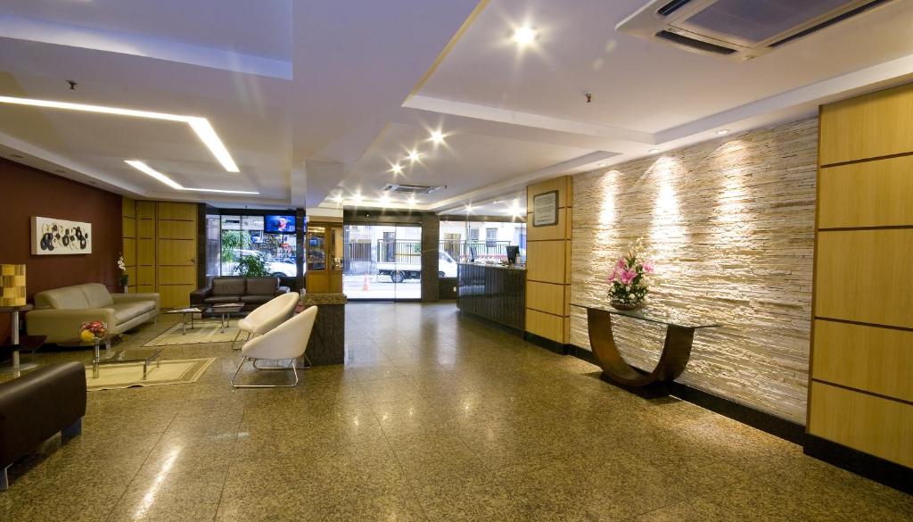 a hallway with a lobby with chairs and a wall at Hotel Rondônia Palace in Rio de Janeiro