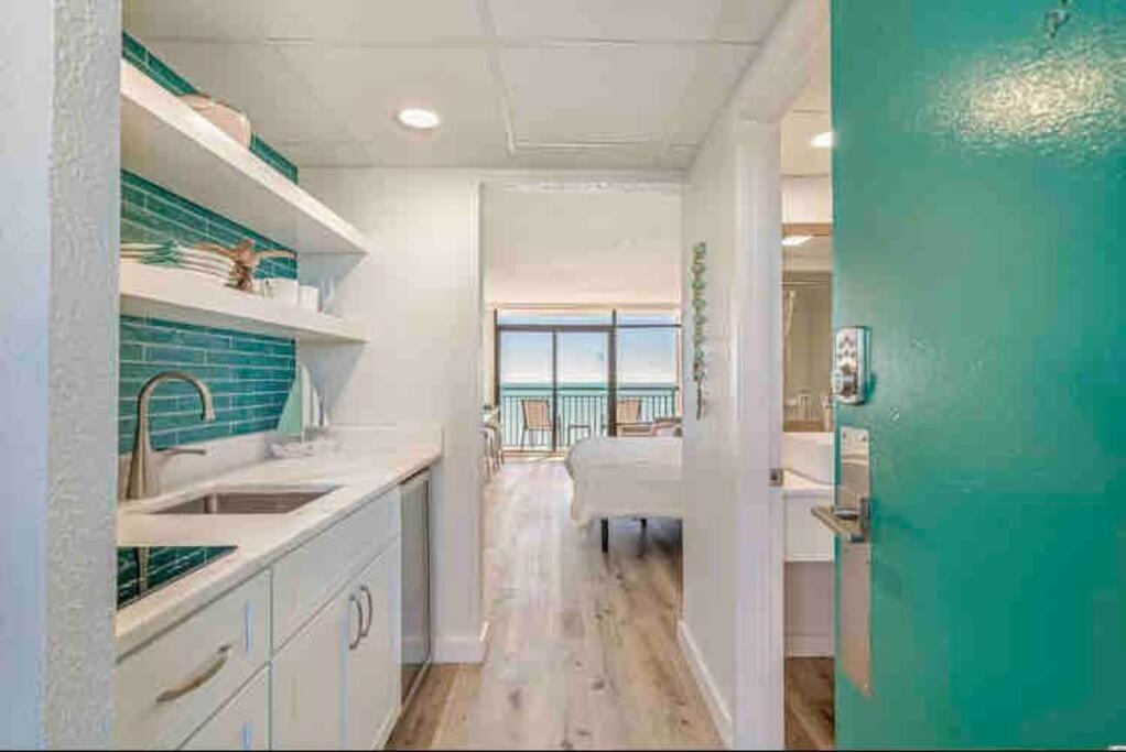 a kitchen with white counters and a green door at Soul Sanctuary-Direct oceanfront-Million dollars view-King bed-Free Parking-Self check-in in Myrtle Beach
