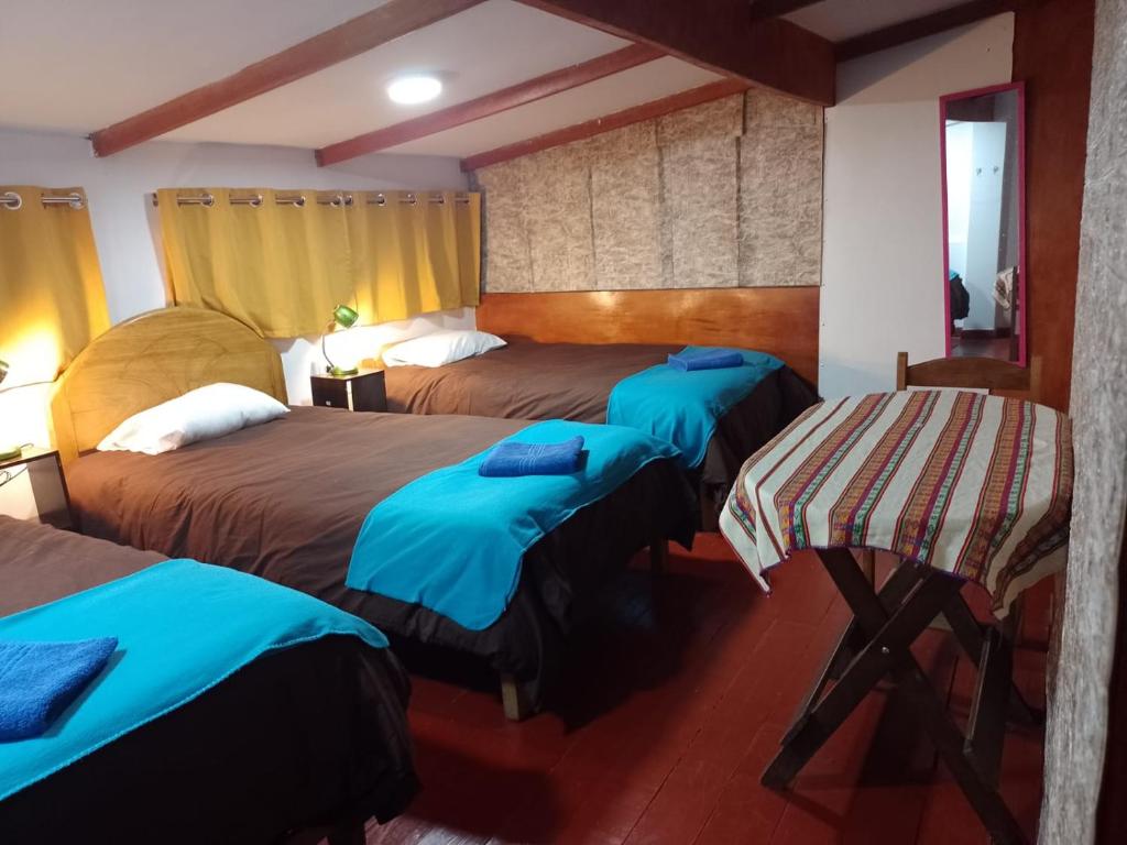 Cette chambre d'hôtel comprend 2 lits avec des draps bleus. dans l'établissement Killitas home&apart, à Cusco