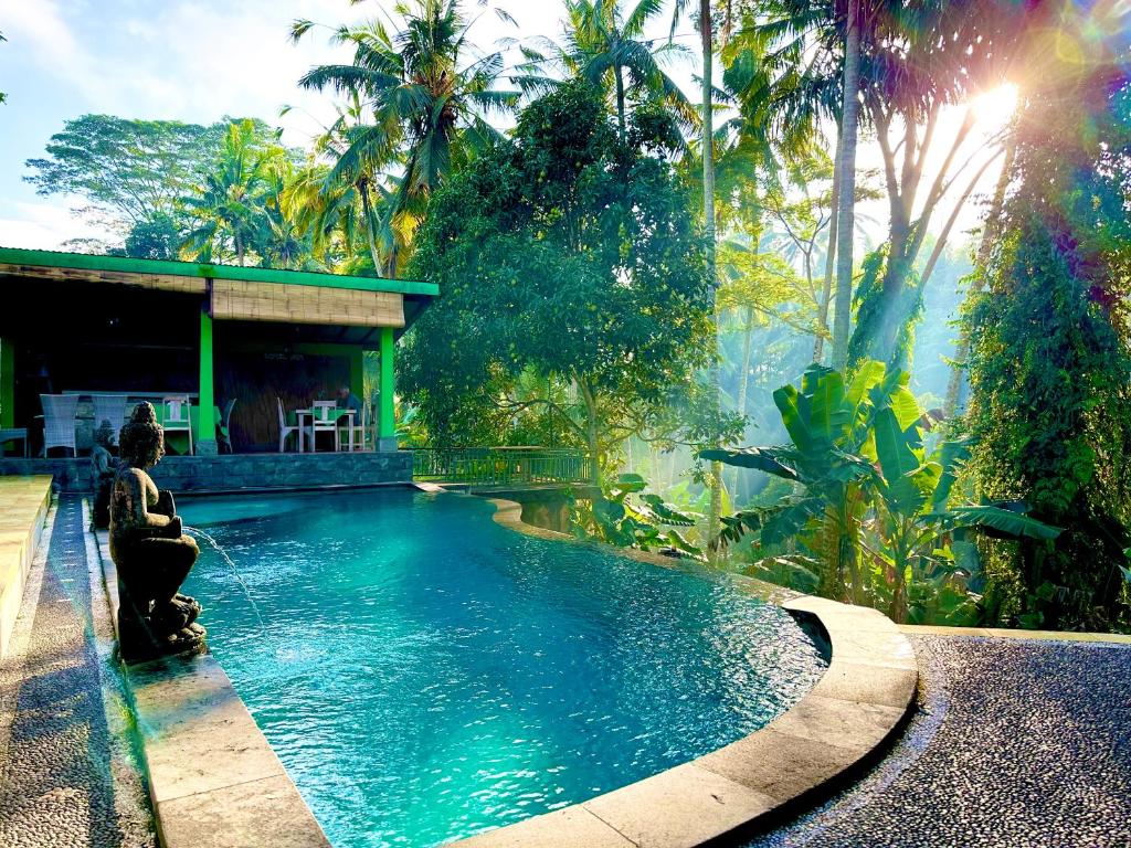 a woman sitting in front of a swimming pool at Dupa Ubud in Ubud