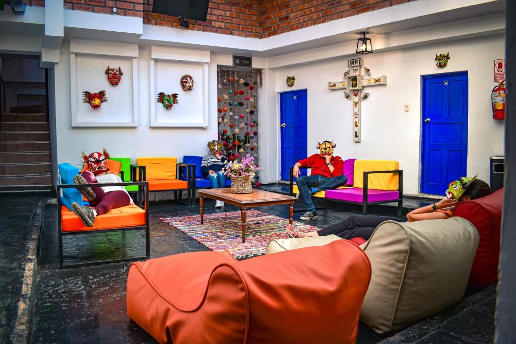Saqray Hostel في كوسكو: مجموعة من الناس يجلسون على الكراسي في غرفة المعيشة