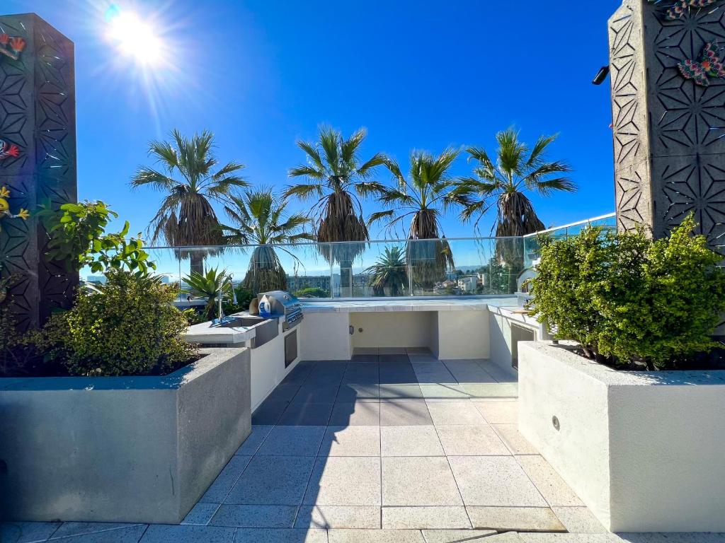 a balcony with palm trees and a view of the ocean at Downtown Los Angeles Skyline balcony view Modern Penthouse in Los Angeles