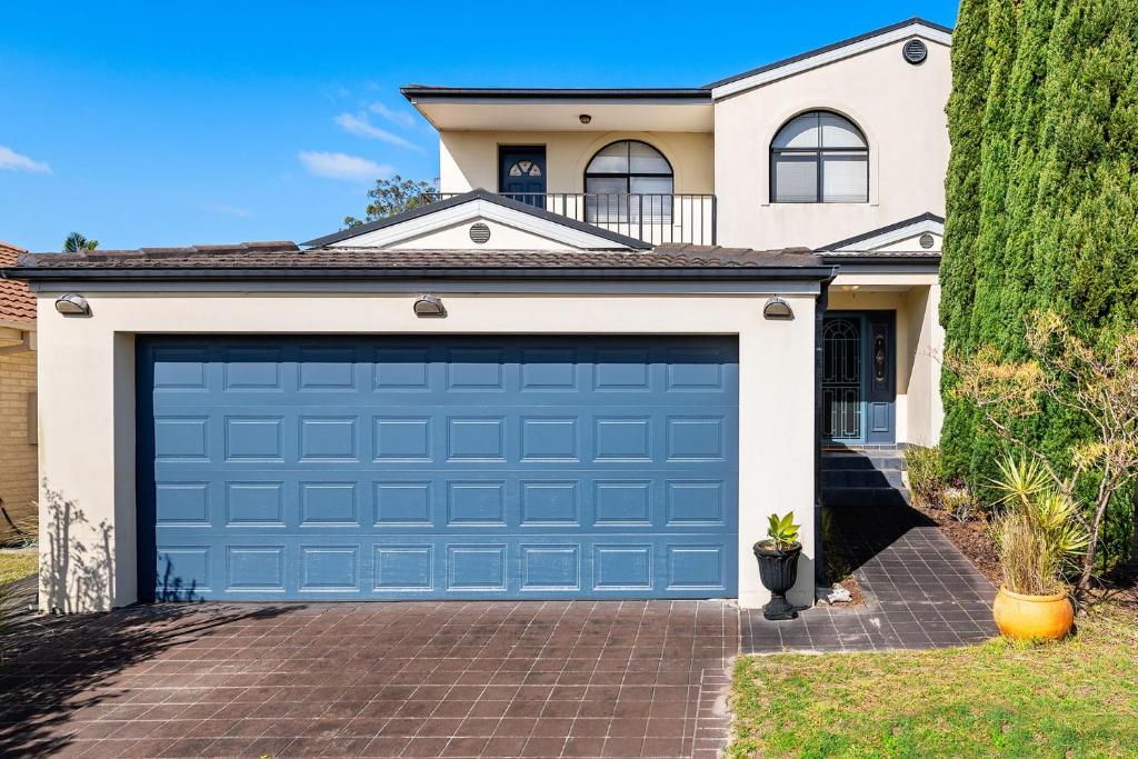 a blue garage door in front of a house at Home away from home at Corlette in Corlette