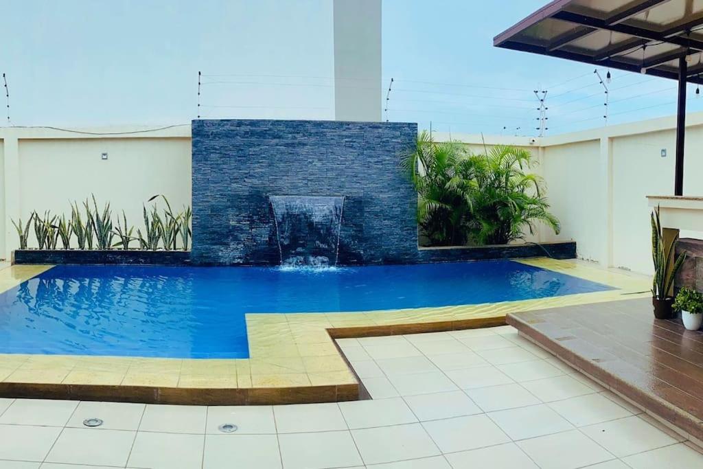 a swimming pool with a fountain in a building at Deluxeguesthouse/vía Spondylus in Manta