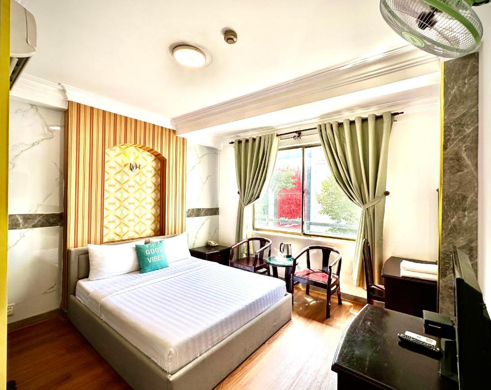 1 dormitorio con cama, escritorio y ventana en Anh Duy Hotel - Nguyễn Công Trứ The Bitexco Neighbour, en Ho Chi Minh