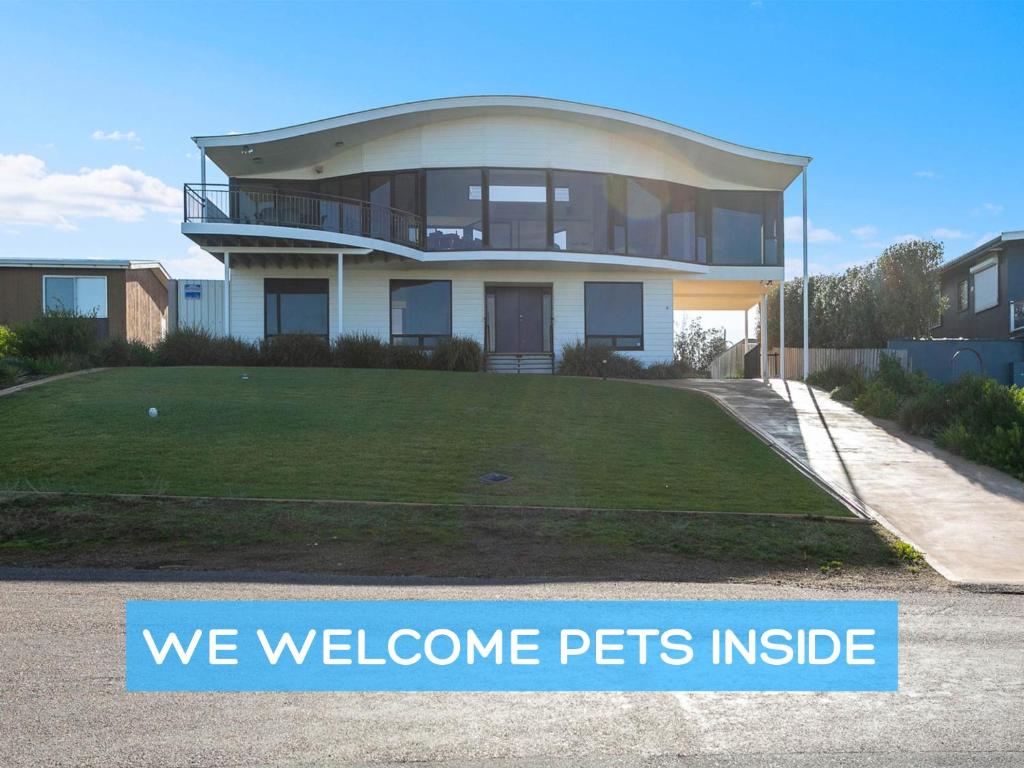 een huis met een bord waarop staat dat we huisdieren welkom heten bij Architect Designed Beach House with Sweeping Views in Goolwa South
