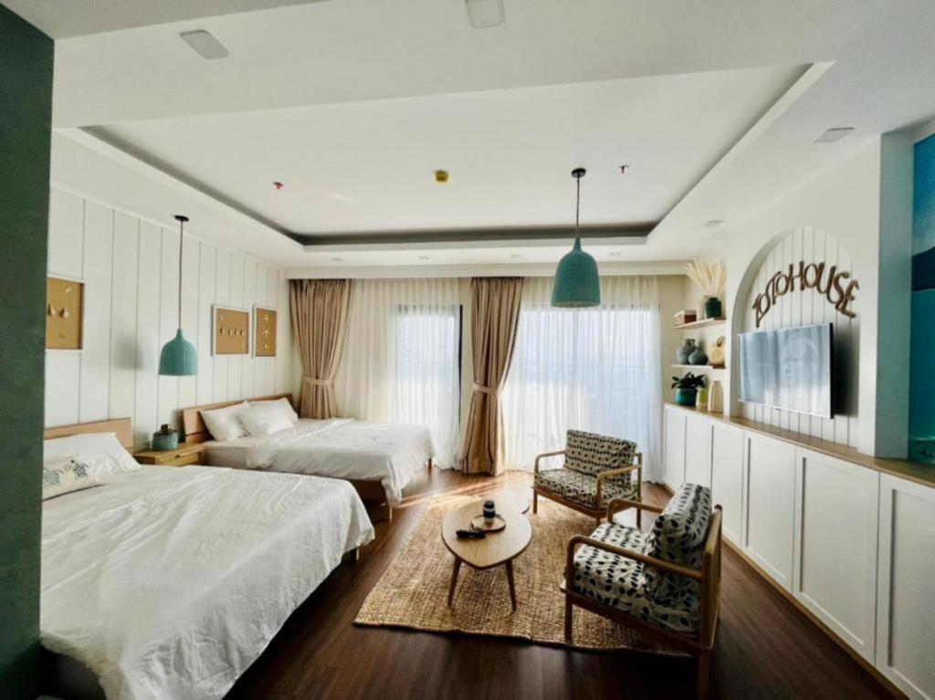 um quarto com 2 camas, uma mesa e cadeiras em FLC Sea Tower Quy Nhơn - Homostay em Quy Nhon