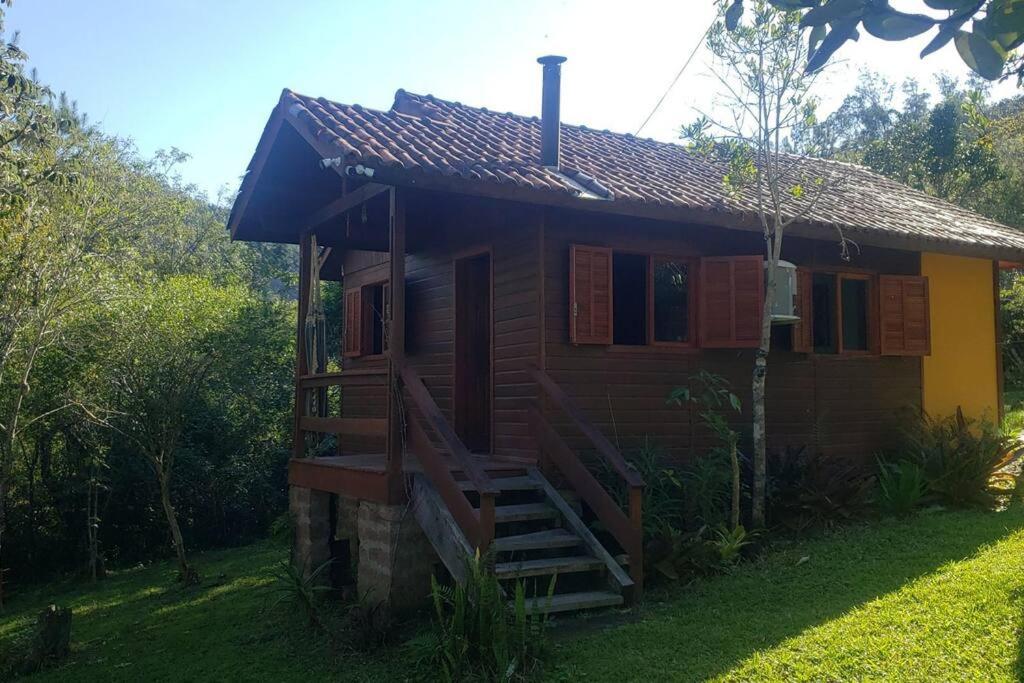 uma pequena casa com uma escada em frente em Cabana Terra Nativa Reserva Natural em Glorinha