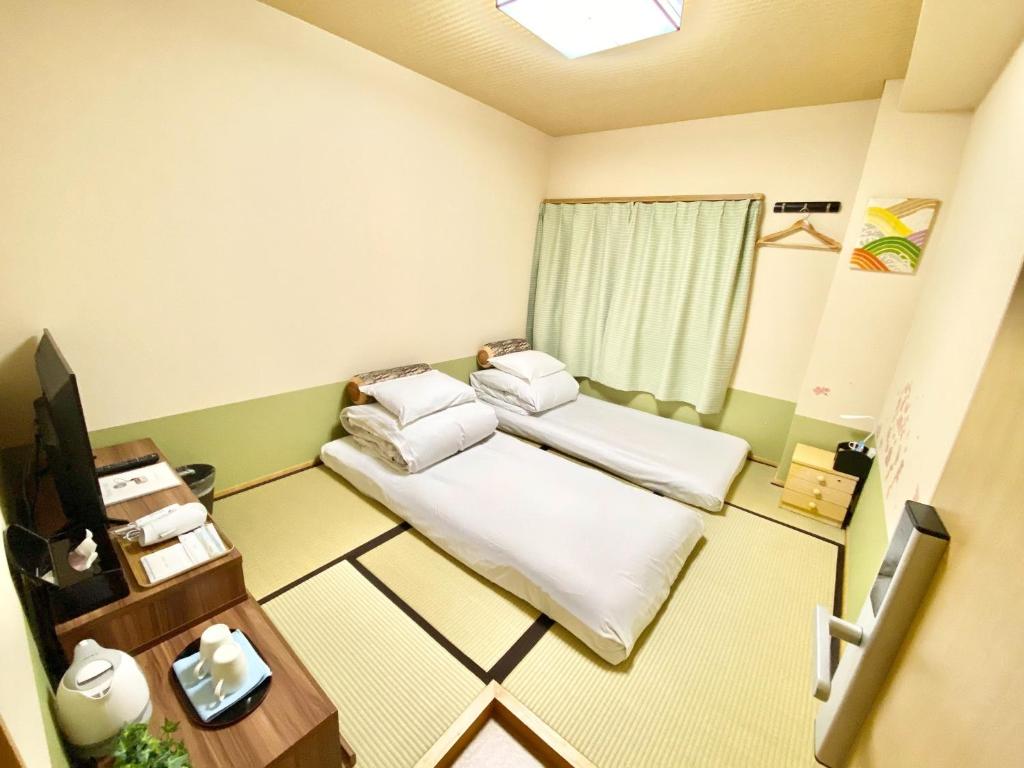 徳島市にあるReinahill - Vacation STAY 14231vのベッド2台とテレビが備わる小さな客室です。