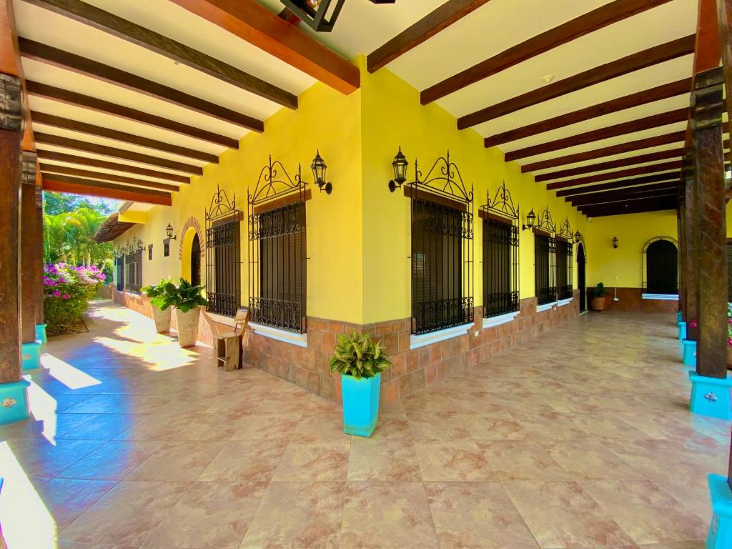 La Unión的住宿－Casa Colonial San Alejo，一座拥有黄色墙壁的建筑和一个种有盆栽植物的庭院