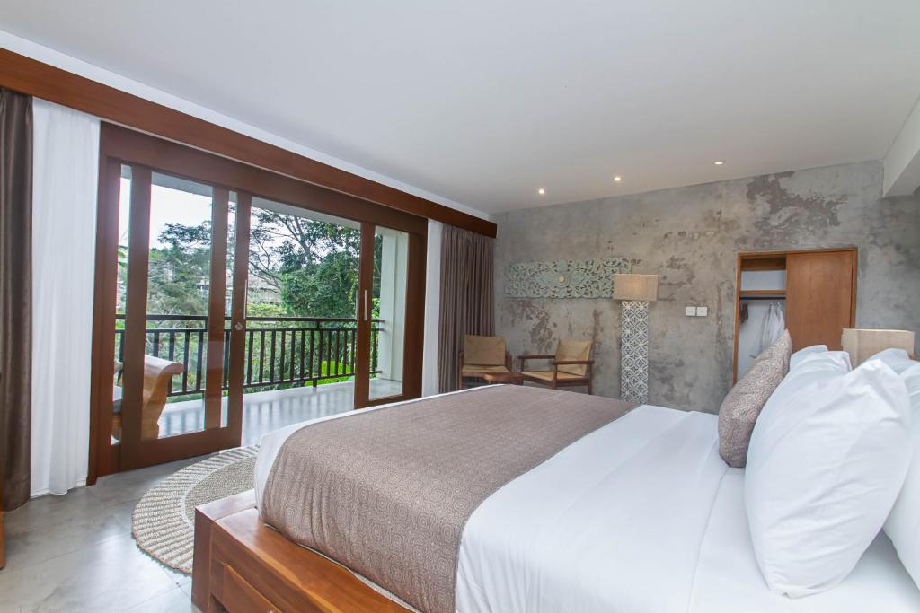 - une chambre avec un grand lit et un balcon dans l'établissement The Hidden Paradise Ubud - CHSE Certified, à Ubud
