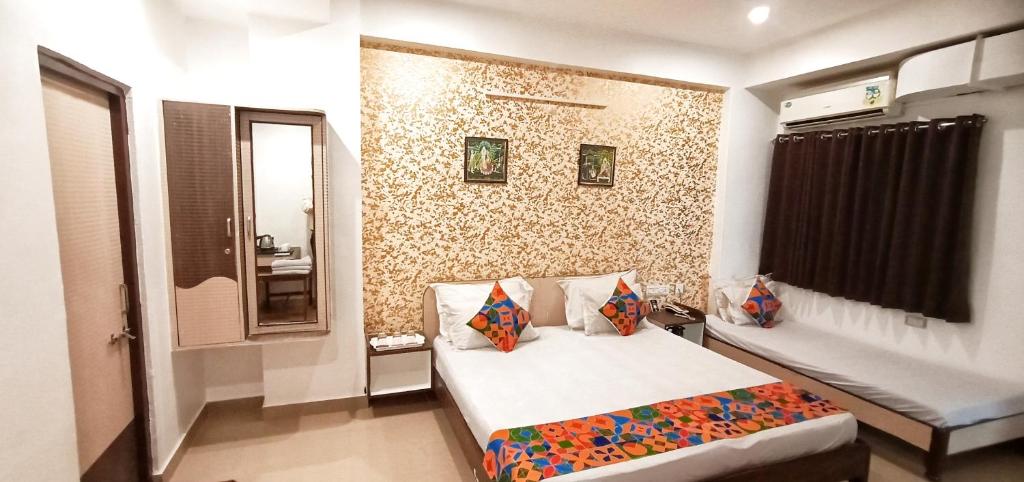 a small bedroom with a bed and a wall at Hotel Omni Plaza in Jodhpur