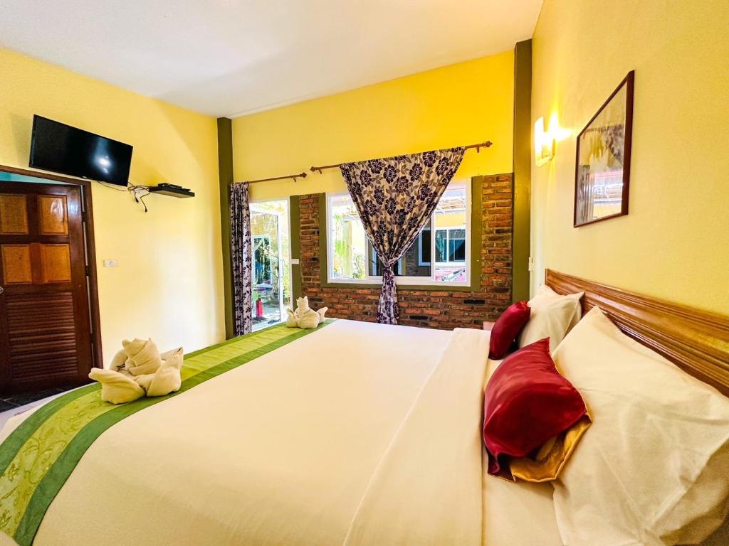 a bedroom with a large bed and a window at Lanta Baan Nok Resort in Ko Lanta