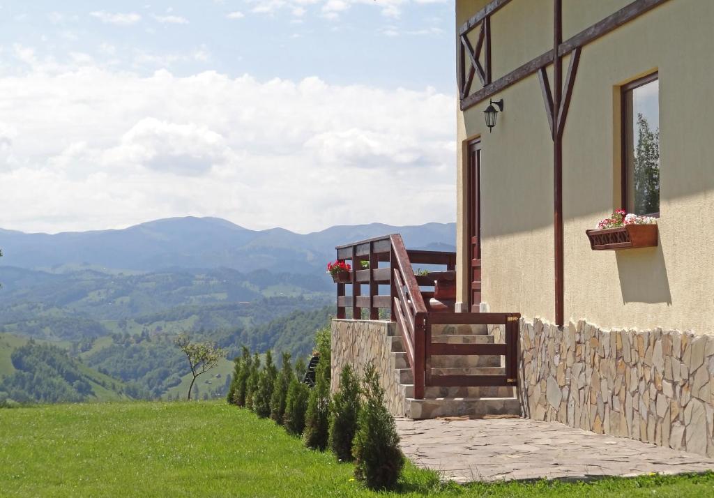 a house with a balcony with a view of mountains at Pension Nea Marin in Măgura