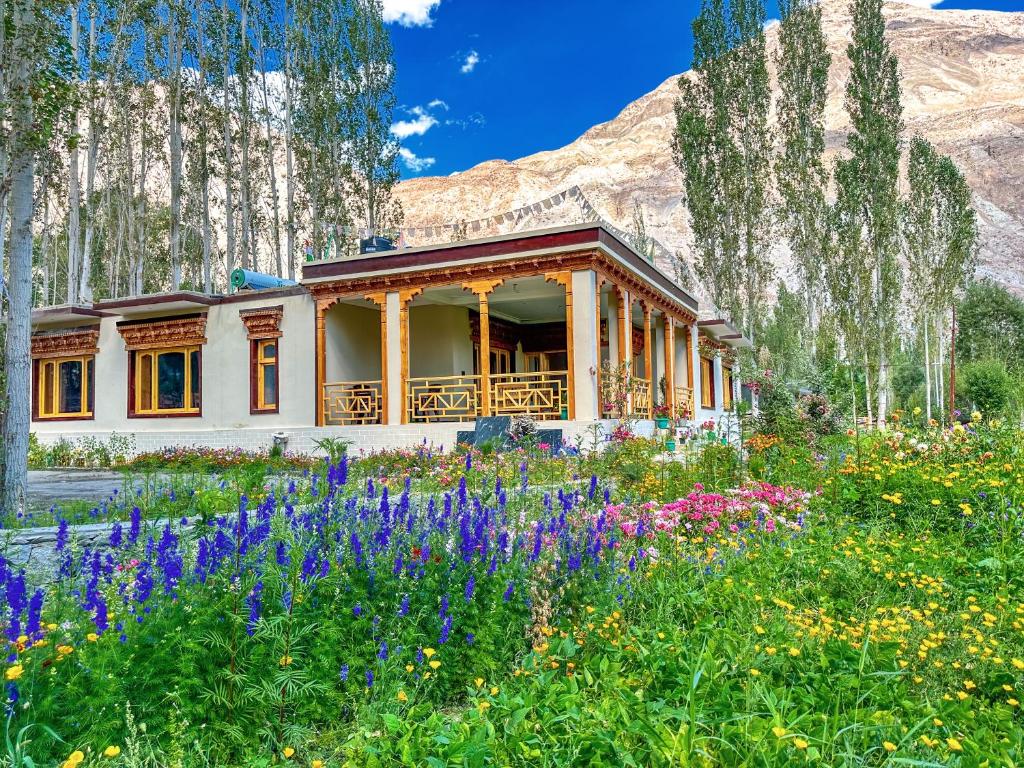a house with a field of flowers in front of it at De Khama in Nubra