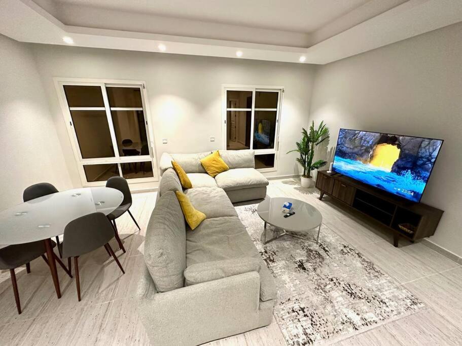 Il comprend un salon doté d'un canapé et d'une télévision à écran plat. dans l'établissement AlYasmin, S&M Luxury Apartment, à Riyad