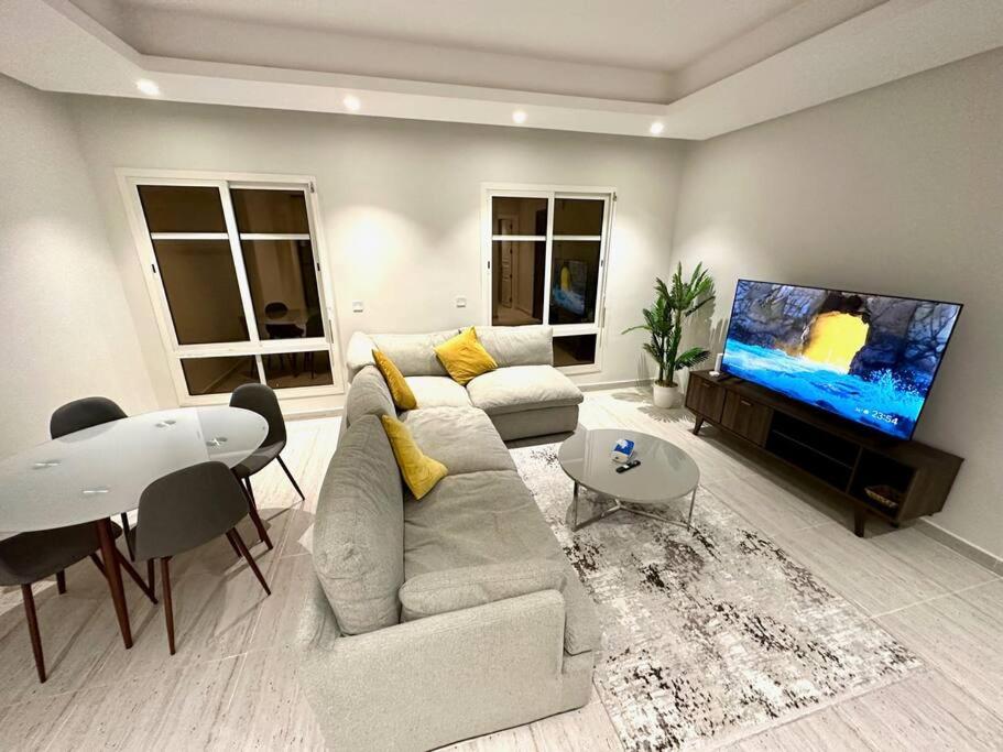 a living room with a couch and a flat screen tv at AlYasmin, S&M Luxury Apartment in Riyadh