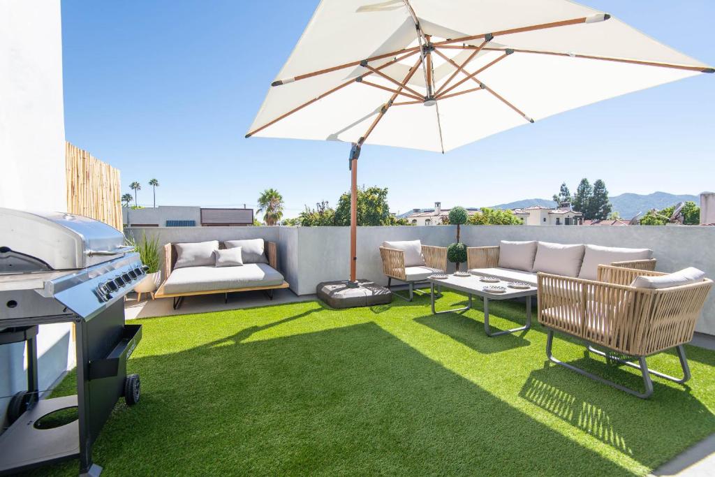 a backyard with a grill and an umbrella at Regency Modern Apartments in Los Angeles