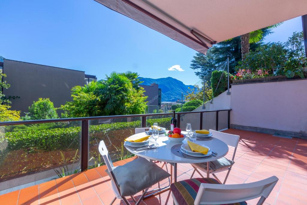 a patio with a table and chairs on a balcony at Lugano Centro- Happy Rentals in Lugano