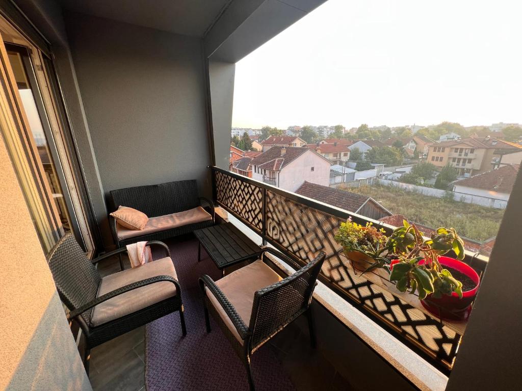 a balcony with chairs and a table and a window at Apartment home in Gjakove