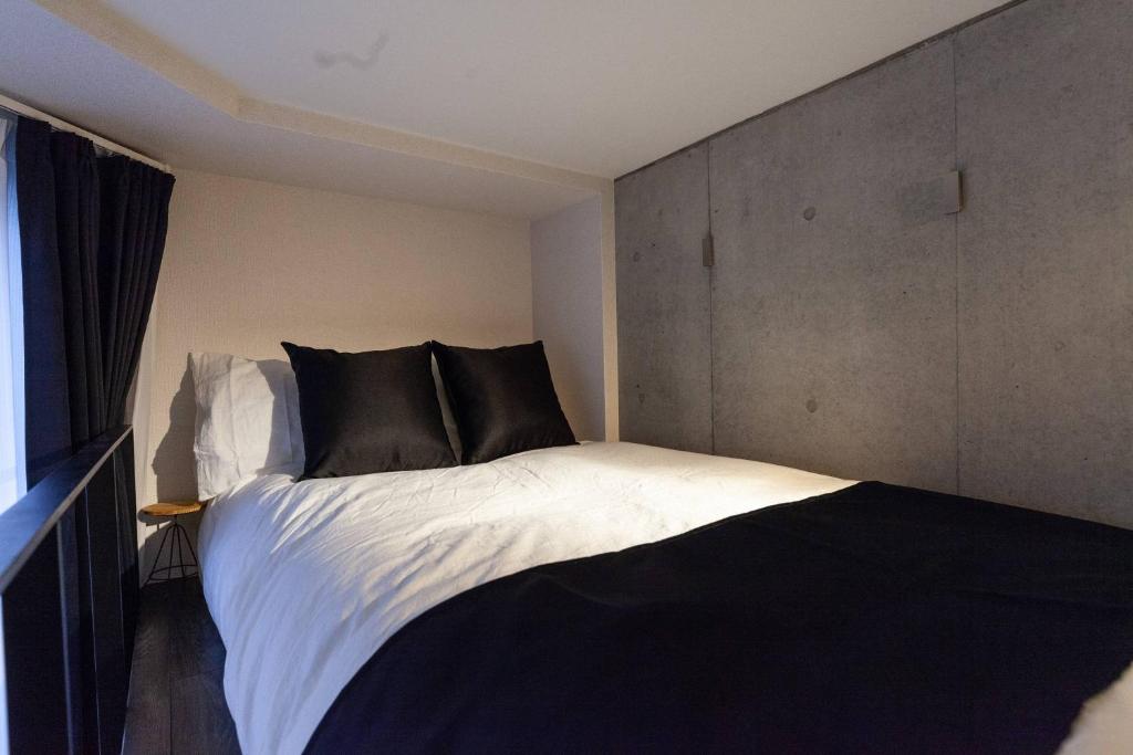 東京的住宿－LAPiS AkasakaⅡ，卧室配有一张带黑色枕头的大型白色床。