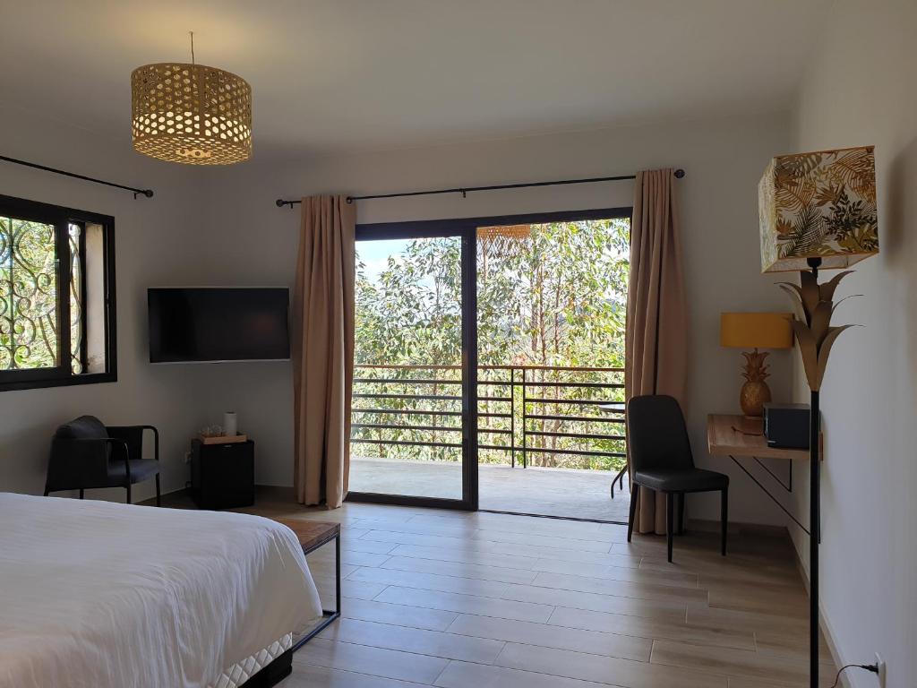 1 dormitorio con 1 cama y puerta corredera de cristal en Relais De Mantadia en Andasibe