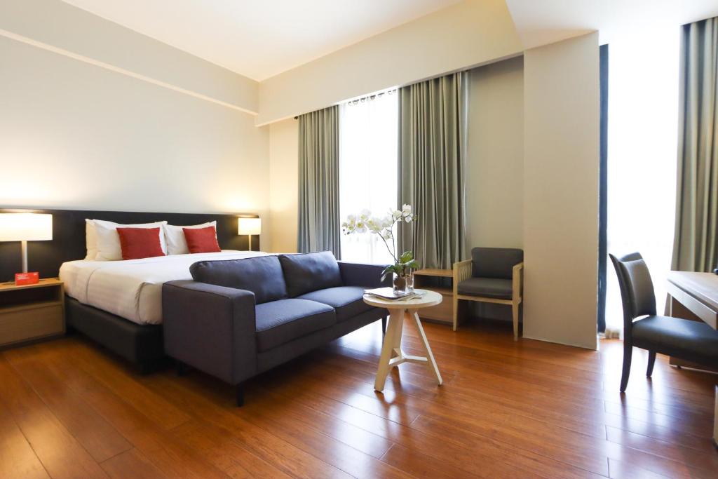 ein Hotelzimmer mit einem Bett und einem Sofa in der Unterkunft Privato Quezon City in Manila
