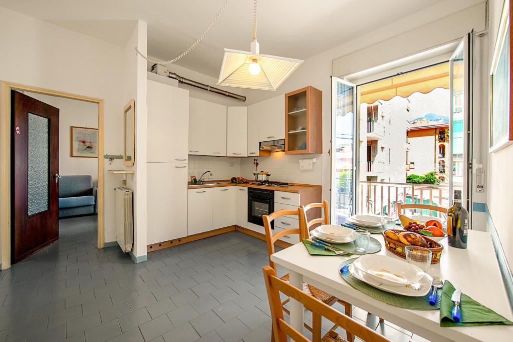 uma cozinha e sala de jantar com mesa e cadeiras em Casa Cabana - 200m From The Sea - Happy Rentals em Alassio