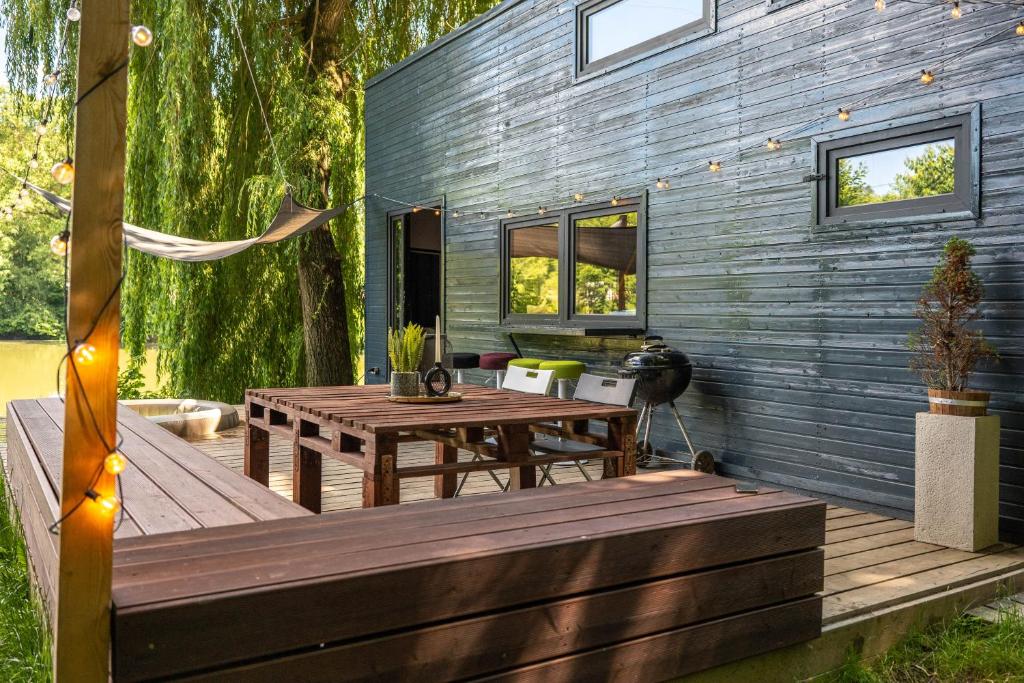 Řehenice的住宿－Secret Lake Prag magic place relaxation& wellness，木制甲板上设有野餐桌