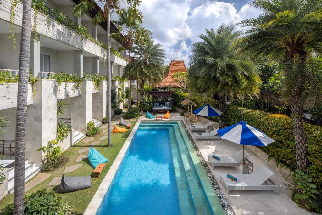 - une vue aérienne sur la piscine d'un hôtel avec des palmiers dans l'établissement Tapa Tepi Kali Canggu, à Canggu