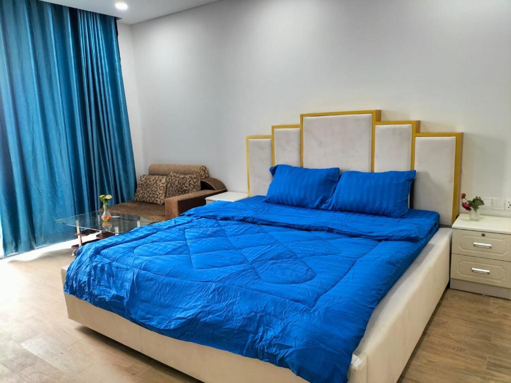 a bedroom with a bed with a blue comforter at Grand Condo 7 in Phnom Penh