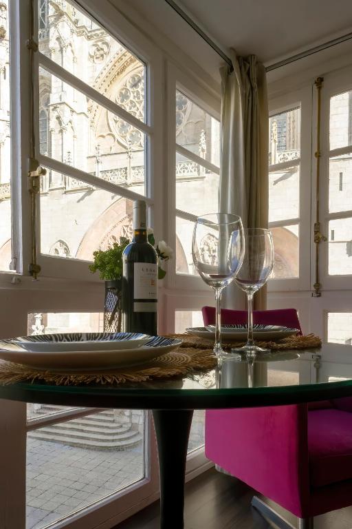 stół z dwoma kieliszkami do wina i oknem w obiekcie La Suite de la Catedral by Unique Rooms w mieście Burgos