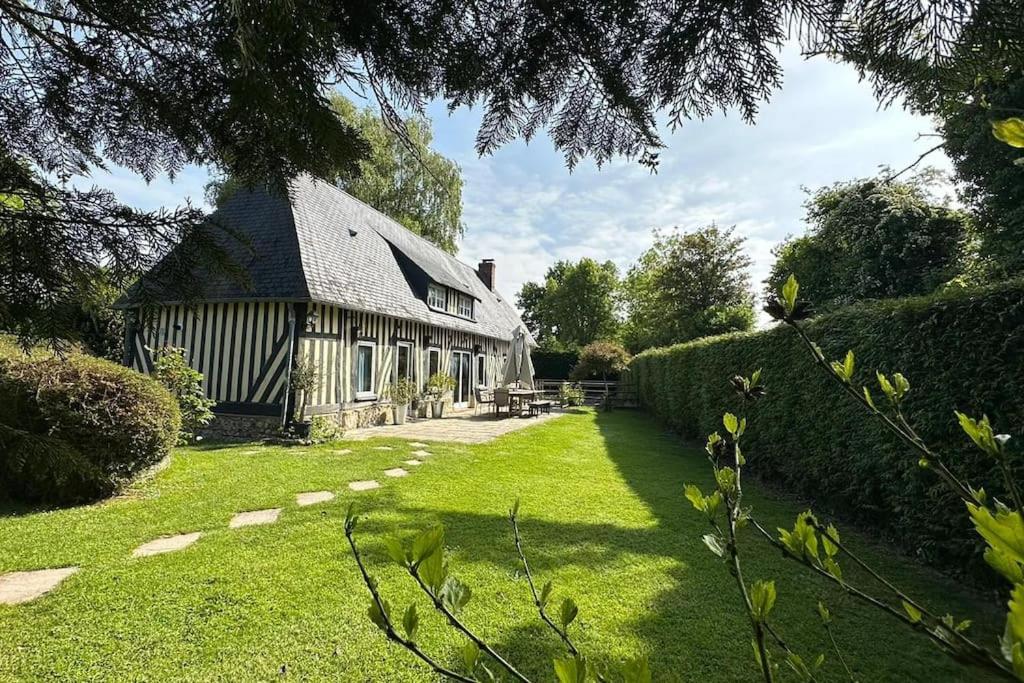 una casa grande con un patio de hierba delante de ella en Maison à colombages près de Deauville, Trouville, en Formentin