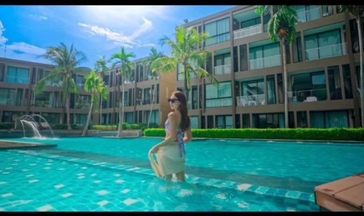 une femme debout dans l'eau dans une piscine dans l'établissement Panwa Beach Side Beachfront, à Phuket