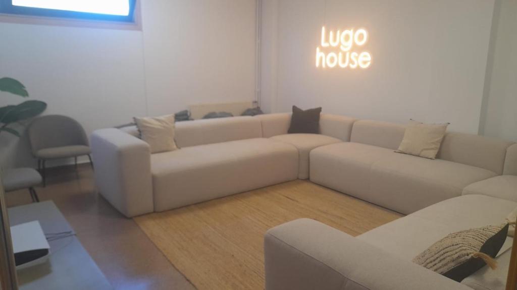 uma sala de estar com um sofá branco e uma mesa em Micampus Lugo Student Residence em Lugo