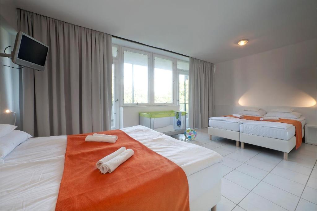 Postel nebo postele na pokoji v ubytování Hotel Holiday Csopak