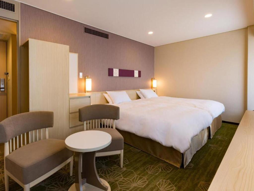 a hotel room with a large bed and a table at Shinjuku Prince Hotel in Tokyo