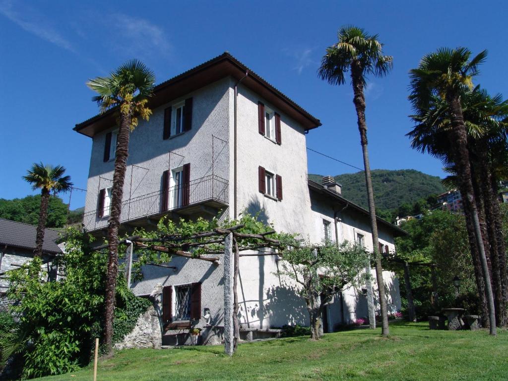 a house with palm trees in front of it at Casa Perini in Tenero