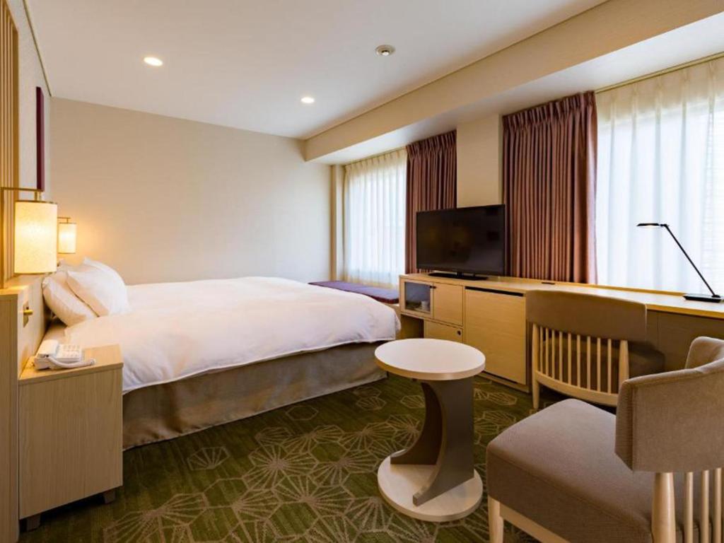 a hotel room with a bed and a flat screen tv at Shinjuku Prince Hotel in Tokyo