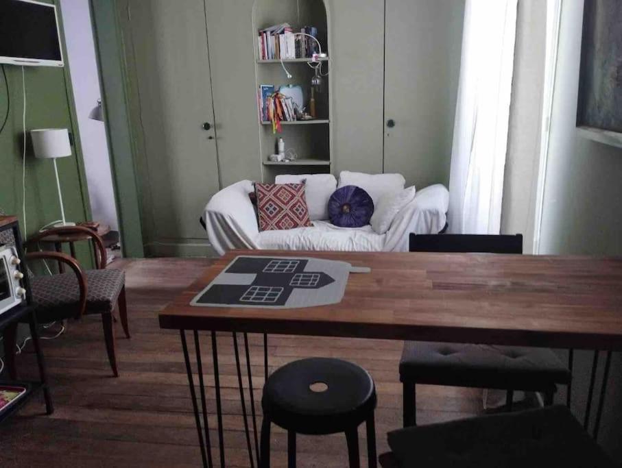 un salon avec un canapé et une table dans l'établissement Cosy Nest in Montmartre, à Paris